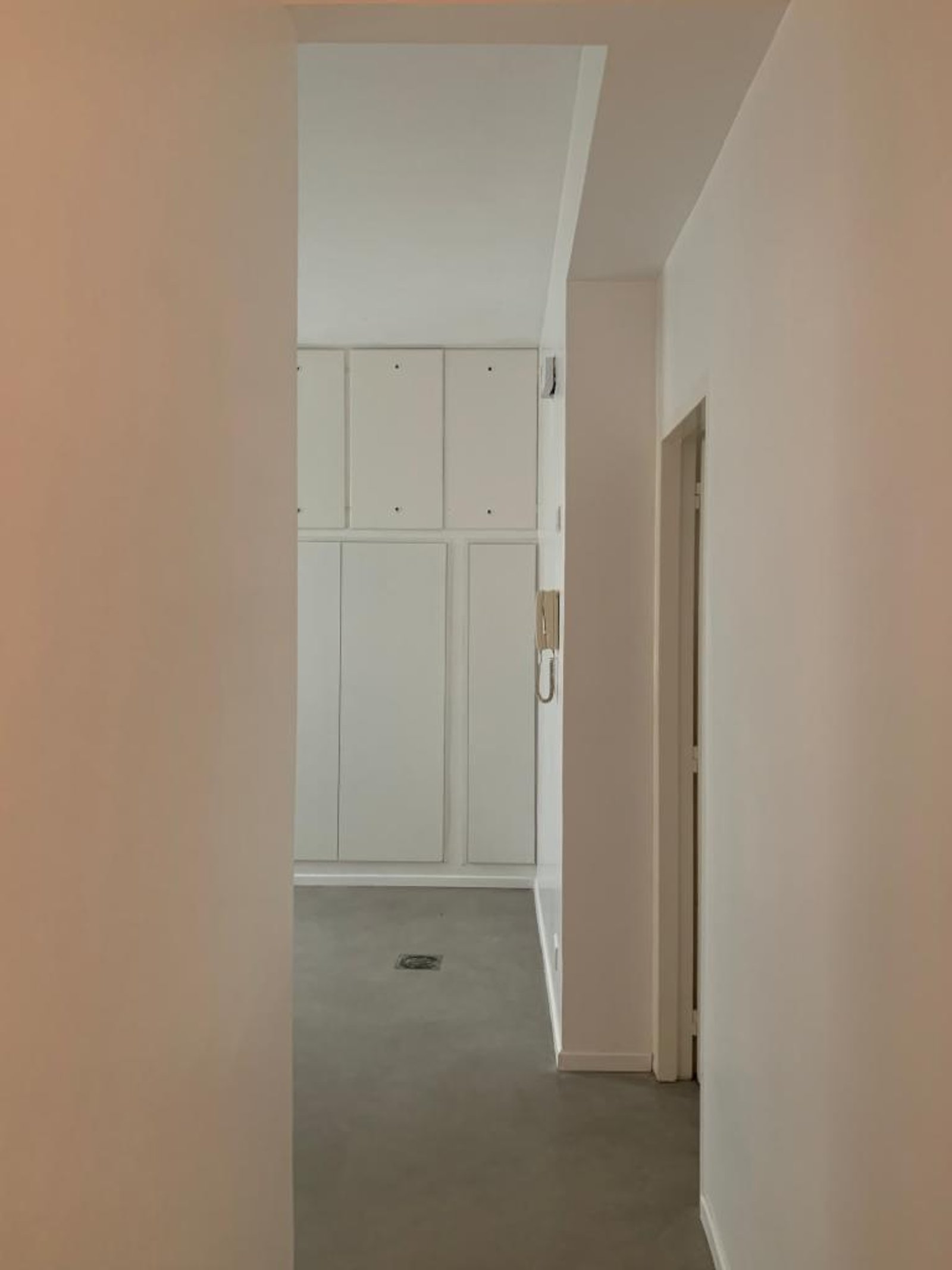 Pasillo moderno con armarios empotrados y piso de cemento pulido — proyecto Montevideo, por cromo., en Recoleta